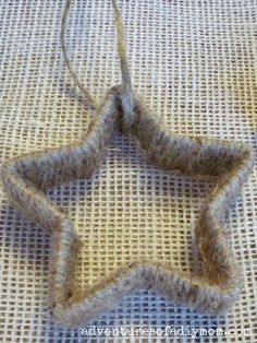 a knitted star ornament sitting on top of a white fabric covered table