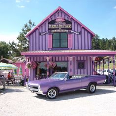 a purple car parked in front of a building