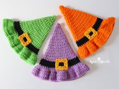 three crocheted witches hats on a white surface