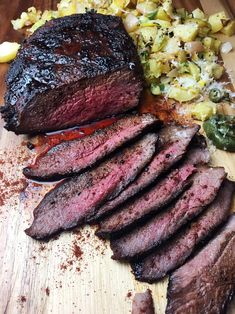 the steak is sliced up and ready to be served on the table with other foods