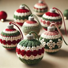 crocheted christmas ornaments are arranged on a table with red, white and green balls