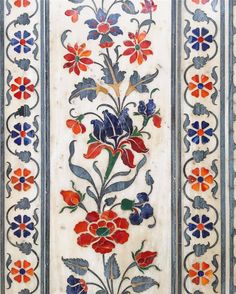 an intricately decorated wall panel with flowers and leaves on white, blue, red and orange colors