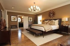 a large bed sitting in the middle of a bedroom on top of a hard wood floor