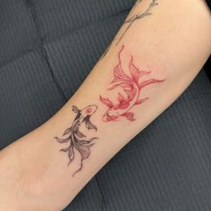 a woman's arm with a fish tattoo on it