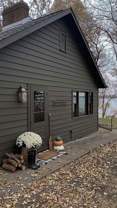 a gray house with white flowers on the porch