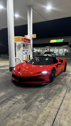 a red sports car parked at a gas station