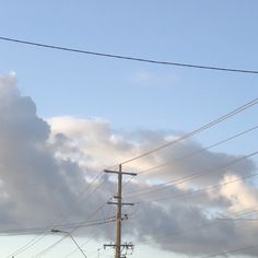 power lines and telephone poles against a blue sky with white clouds in the back ground