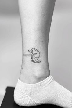 a woman's foot with a small tattoo on the left side of her ankle