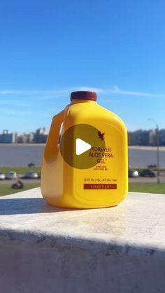 a yellow jug sitting on top of a cement wall