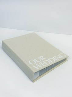 a white book with the words our wedding written on it's front and back cover