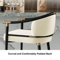 the curved and comfortably padded back chair is next to a wine glass rack with bottles on it