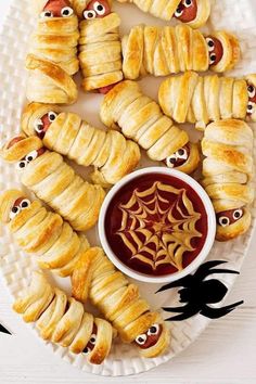 halloween treats are arranged on a plate with eyes and spider webs in the middle