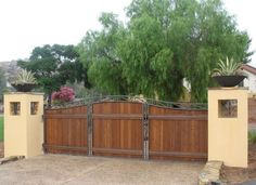 a gated driveway with trees in the background