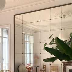 a living room filled with furniture and a large mirror over the top of a table