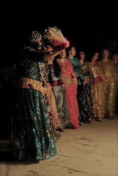 a group of people standing next to each other in front of a dark room with lights on