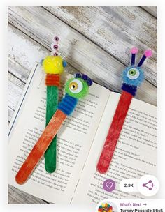 two bookmarks made out of toothbrushes with eyes on them sitting on top of an open book