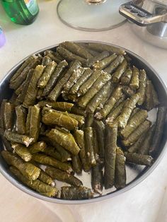 there is a large metal bowl filled with pickles next to other items on the table