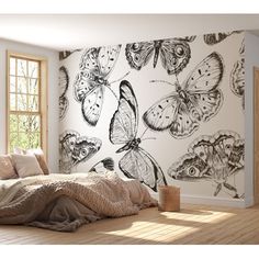 a bedroom with butterflies painted on the wall and bed in the foreground, next to a window