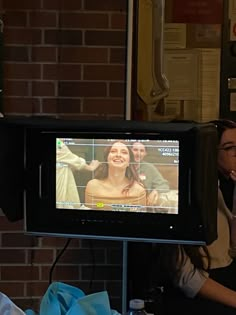 a woman standing in front of a tv with a smile on it's face