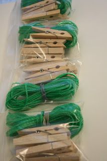 several wooden clothes pins and green string in plastic bag on white table top with clear cellophane wrapper