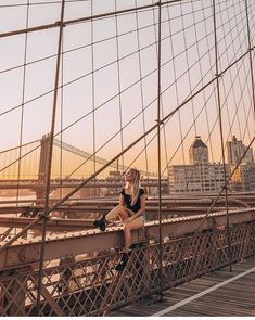 a woman sitting on the edge of a bridge