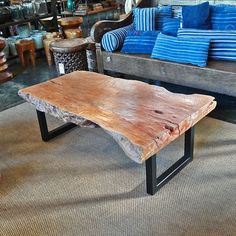 a wooden table sitting on top of a carpeted floor next to two couches