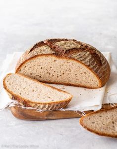 a loaf of bread sitting on top of a white cloth next to two slices of bread