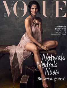 a woman sitting on top of a wooden bench in front of a cover of a magazine