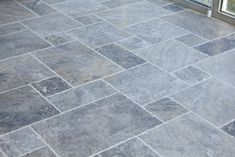 an outdoor patio with stone tiles on the floor and sliding glass doors to the outside