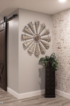 a room with a brick wall and a large metal windmill on the wall