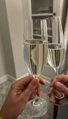 two people toasting with wine glasses on a table