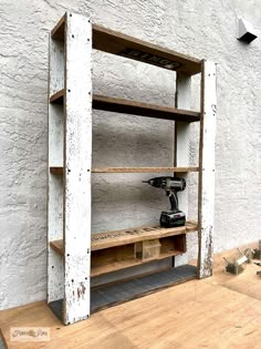 a driller is sitting on top of a wooden shelf next to a white wall