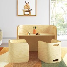 a child's wooden bench and stool in a room with a painting on the wall