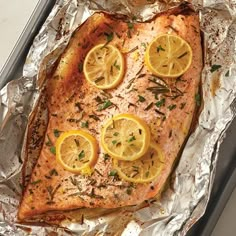 salmon with lemons and herbs on aluminum foil