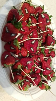 strawberries are arranged on skewers with toothpicks