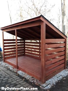 a small wooden shelter sitting on top of a brick walkway