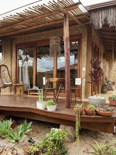 a wooden deck with potted plants on it next to a building and patio area