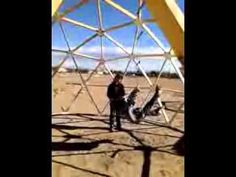 a man standing in front of a metal structure