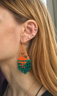 a close up of a person wearing some kind of earring with beads on it