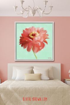 a bedroom with pink walls and a large painting on the wall above the headboard