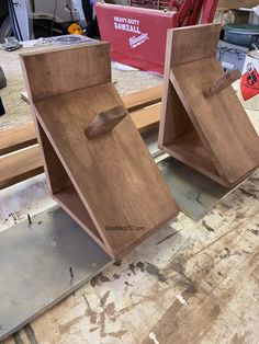 two wooden boxes sitting on top of a workbench with tools in the background