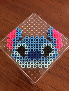 an image of a bead art project on a wooden table with beads in the shape of a cat