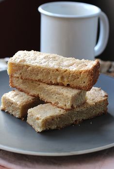 three pieces of cake sitting on top of a plate next to a cup and saucer