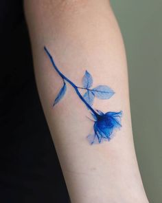 a blue rose tattoo on the arm