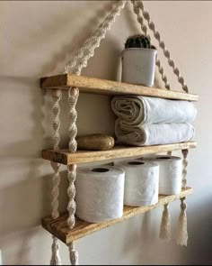 a shelf with several rolls of toilet paper on it and some rope hanging from the wall