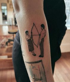 a man with a bow and arrow tattoo on his arm