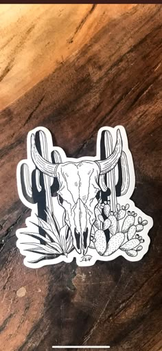 a sticker with an image of a bull's skull and cactuses on it