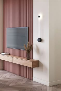 a flat screen tv mounted to the side of a wall next to a wooden shelf