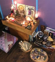 a wooden table topped with lots of different types of items next to candles and pictures