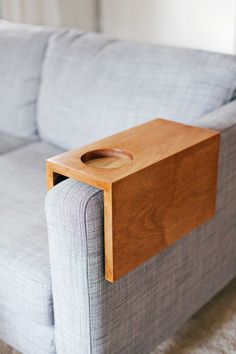 a gray couch with a wooden tray on it